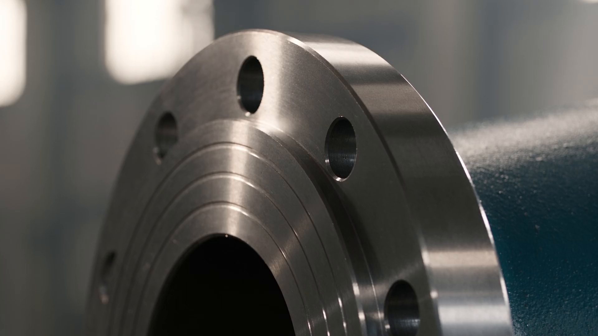 A forged steel weld-neck flange, its turned sealing face close up.